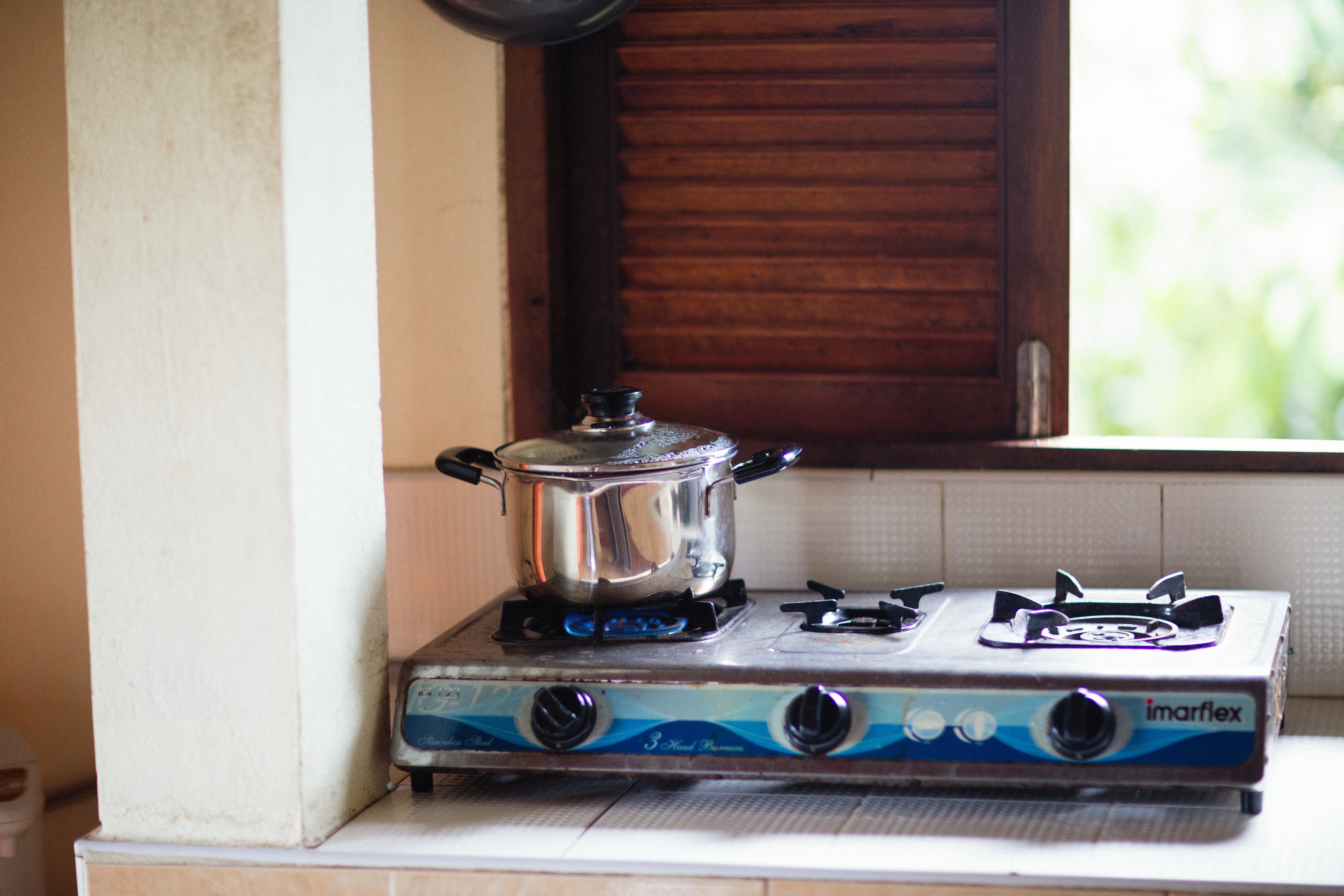 Een kookpan op een gasfornuis in een lichte keuken